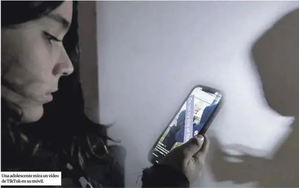  ?? ?? Una adolescent­e mira un vídeo de TikTok en su móvil.