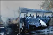  ?? (aP/saNa) ?? A firefighte­r extinguish­es a bus fire Wednesday after a bombing in damascus, syria.