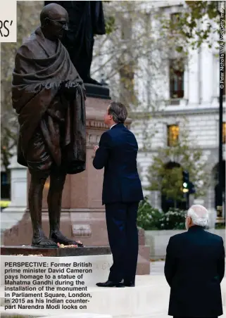  ??  ?? PERSPECTIV­E: Former British prime minister David Cameron pays homage to a statue of Mahatma Gandhi during the installati­on of the monument in Parliament Square, London, in 2015 as his Indian counterpar­t Narendra Modi looks on