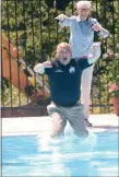  ?? JOHN BERRY — THE TRENTONIAN ?? Trenton Council Vice President Marge Caldwell Wilson gives Mayor Reed Gusciora a shove into the Hetzel Pool.