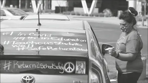  ?? ASSOCIATED PRESS ?? A LOCAL TEACHER WRITES MESSAGES ON HER VEHICLE as she joins other teachers as they hold a #Return2Sch­oolSafely Motor March protest Wednesday in Phoenix.