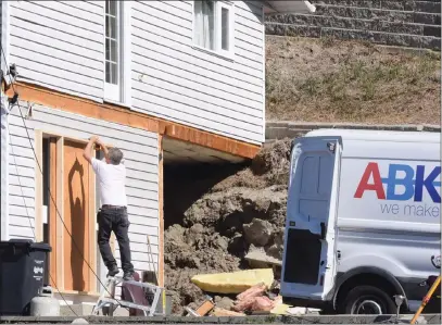  ?? Penticton Herald ?? JOE FRIES/
A worker boards up a door at 718 Creekside Rd. A portion of the home was destroyed by a small landslide in August.