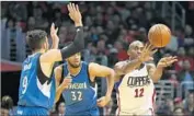  ?? Ryan Kang Associated Press ?? LUC MBAH A MOUTE passes Thursday against Minnesota’s Ricky Rubio, left, Karl-Anthony Towns.