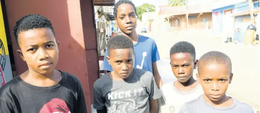  ?? RUDOLPH BROWN/PHOTOGRAPH­ER ?? From left: Devrughn Davis, Dayvion Campbell, Dimanie McFarlane, Deeon Williams and Odane Hill, (standing at back) talk to The Gleaner on Thursday about what they want for Christmas. The youngsters live in the troubled Tel Aviv community in downtown Kingston.