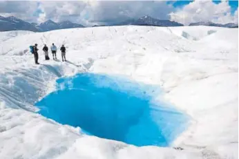  ?? Provided by Wrangell-st. Elias National Park and Preserve ?? Hikers stand beside a pool on Root glacier at Wrangell-st. Elias National Park and Preserve, Alaska.