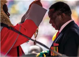  ??  ?? New Zimbabwean president Emmerson Mnangagwa receiving the chain and sash of office as he is sworn in, Harare, November 24, 2017