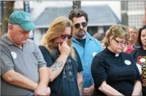  ?? MARIAN DENNIS — DIGITAL FIRST MEDIA ?? Attendees at a vigil for Charlottes­ville that was held in Smith Family Plaza Thursday hang their heads in a moment of silence to remember the victims in Charlottes­ville.