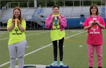  ?? Scott Herpst ?? Ringgold High School’s Anna Garner and Allie Henley, along with Heritage High’s Caedon Summers, proudly show off their ribbons after competing in their heat of the 100-yard dash. The Special Olympics returned to Catoosa County this past Friday for the first time since 2019.