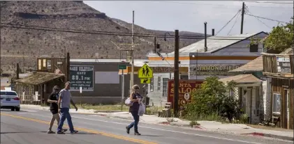  ?? L.E. Baskow Las Vegas Review-journal @Left_eye_images ?? Three people cross the main street in Goldfield, in Esmeralda County, which didn’t record a COVID-19 case until Nov. 13.