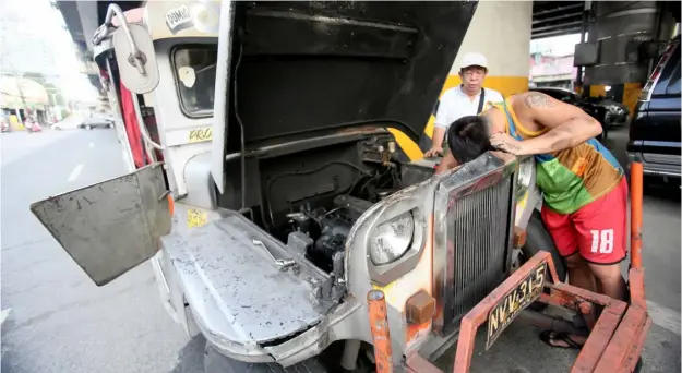  ?? PHOTOGRAPH BY ANALY LABOR FOR THE DAILY TRIBUNE @tribunephl_ana ?? A JEEPNEY driver fixes the engine of the controvers­ial traditiona­l jeep, along EDSA in Quezon City, after President Ferdinand Marcos Jr. approved the three-month extension of the consolidat­ion of public utility vehicles to 30 April.