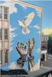  ?? Cory Pane / Contribute­d photo ?? The mural at the WAPJ building in Torrington titled “A New Dawn,” which shows hands releasing a dove.