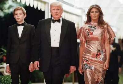  ??  ?? President Donald Trump arrives for a New Year's Eve gala at his Mar-a-Lago resort with first lady Melania Trump and their son Barron Sunday in Palm Beach, Fla. (AP)