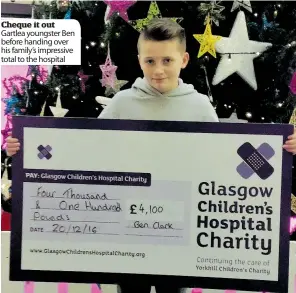  ??  ?? Cheque it out Gartlea youngster Ben before handing over his family’s impressive total to the hospital
