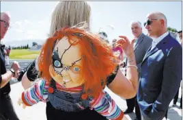  ?? Cathleen Allison ?? Las Vegas Review-journal Wooster High School principal Leah Keuscher wears her a Chucky doll to welcome Raiders president Marc Badain on a tour of the campus Thursday in Reno.