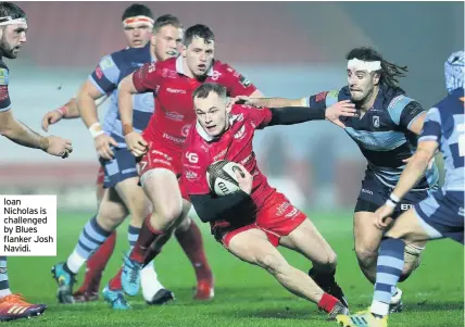  ??  ?? Ioan Nicholas is challenged by Blues flanker Josh Navidi.