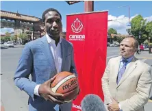  ??  ?? With the entrance to Chinatown in the background, Rowan Barrett, assistant GM of Canada Basketball, addresses the media while Bill Cooper, chairman of the local organizing committee, looks on.