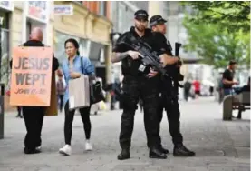  ?? — AFP ?? MANCHESTER: Armed police secure a street in central Manchester yesterday following the May 22 terror attack at the Manchester Arena.