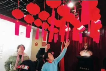  ??  ?? Children try to figure out riddles attached to traditiona­l lanterns at Gu Zhenghong Memorial Hall, which is hosting a traditiona­l riddle guess event to raise traditiona­l Chinese cultural awareness among teenagers.