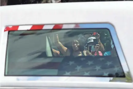  ?? JOE RAEDLE/GETTY IMAGES ?? People seen through the windows of the hearse carrying the casket of Rep. John Lewis watch as it passes Thursday at the South View Cemetery in Atlanta.