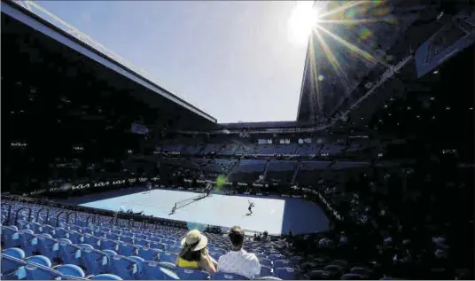  ?? DAVE HUNT / EFE ?? Dos espectador­s, ahir a la pista Rod Laver de l’Open d’Austràlia. A partir de dissabte està prohibit l’accés de públic.