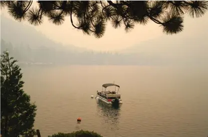  ?? RICH PEDRONCELL­I/AP ?? Smoke from the Caldor Fire shrouds Fallen Leaf Lake on Tuesday near South Lake Tahoe, Calif.