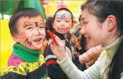  ?? XU CONGJUN / FOR CHINA DAILY ?? Children get their faces painted at a kindergart­en in Nantong, Jiangsu province.