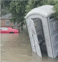  ?? DAN JANISSE ?? A partially submerged Mustang and portable outhouse were among the casualties of Thursday’s flooding.