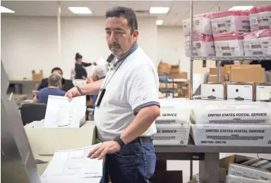  ??  ?? Gary Ramirez processes ballots on Wednesday at the Maricopa County Tabulation and Election Center in Phoenix. If the final tally in the U.S. Senate race remains too close to call, it could trigger a recount. MARK HENLE/THE REPUBLIC