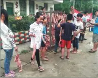  ?? ZHANG SHIJIE / CHINA NEWS SERVICE ?? Students take home pork as an award at Zhiliao Primary School in Sanjiang county in the Guangxi Zhuang autonomous region on Friday. Those who scored over 80 in their Chinese and math final exams were awarded 1 kilogram of pork. The prize has been...