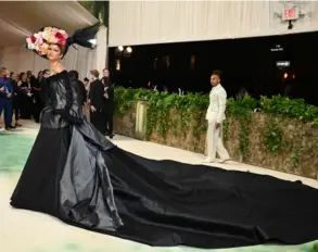  ?? AFP ?? En la MET Gala 2024 Zendaya optó por un vestido negro de cola con un sombrero de flores en tonos amarillos y rojos.