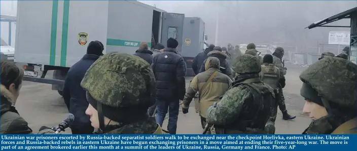  ?? Photo: AP ?? Ukrainian war prisoners escorted by Russia-backed separatist soldiers walk to be exchanged near the checkpoint Horlivka, eastern Ukraine. Ukrainian forces and Russia-backed rebels in eastern Ukraine have begun exchanging prisoners in a move aimed at ending their five-year-long war. The move is part of an agreement brokered earlier this month at a summit of the leaders of Ukraine, Russia, Germany and France.