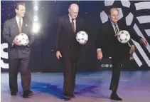  ??  ?? FIFA GENERAL SECRETARY Joseph Blatter (R) kicks a ball as he walks off the stage with FIFA President Dr. Joao Havelange (C) and World Cup USA 1994 Chairman Alan Rothenberg, following the unveiling of the official ball to be used in the World Cup in the...