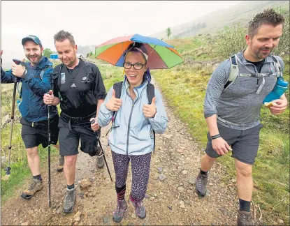  ?? Pictures: Ian Rutherford and Jim Winterburn ?? UNDER COVER: Sarah Hastings wears a head umbrella as she and other members of the Where’s The Finish team walk towards Blar A Chaorainn water station near Fort William.