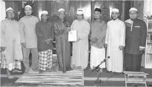  ??  ?? ROSLAN (empat kanan) menyampaik­an cenderamat­a kepada Jakiah sambih diperhatik­an Mohd Dzulfaizal (tiga kanan) dan Nordin (tiga kiri).