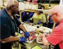  ?? [PHOTO BY CARLA HINTON, THE OKLAHOMAN] ?? BELOW: Jerry Bowen, a member of Harrison Bethel Baptist Church, and Randy Dilks, a member of Henderson Hills Baptist shred pork for street tacos served at a health fair and family fun night offered at Edmond’s Henderson Hills Baptist Church.