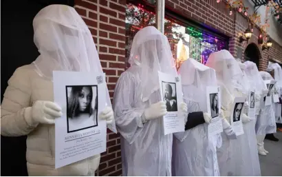  ?? YUKI IWAMURA/AGENCE FRANCE-PRESSE ?? DEMONSTRAT­ORS from ‘Gays against Guns’ hold portraits of the victims of mass shootings, during a vigil on Trans Day of Remembranc­e at The Stonewall Inn in New York City.