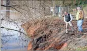  ?? Photos by Doug Walker ?? BELOW: Rome Water &amp; Sewer Department Director Mike hackett (left) and Tim Brunson, assistant director, check out a river bank washout near the Etowah River water intake station