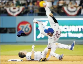  ?? SEAN M. HAFFEY/GETTY IMAGES ?? New York shortstop Ruben Tejada falls after a slide by Los Angeles’ Chase Utley. Tejada broke his leg on the play and Utley has been suspended for two games.