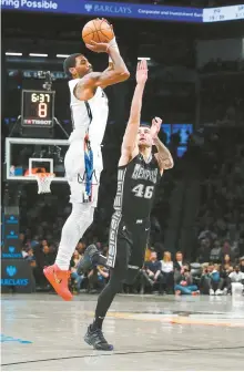  ?? AP-Yonhap ?? Brooklyn Nets guard Kyrie Irving, left, shoots over Memphis Grizzlies forward John Konchar (46) during the second half of an NBA basketball game in New York, Sunday. Nets won 127-115.