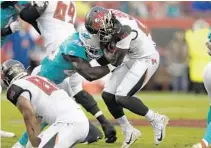  ?? JASON BEHNKEN /AP ?? Dolphins linebacker Sam Eguavoen, a former standout in the CFL, tackles Buccaneers running back Ronald Jones II during Friday night’s preseason game in Tampa.