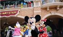  ?? ?? From left: visitors take photos at the 2016 opening of Shanghai Disneyland; Mickey and friends welcome guests back at a recent reopening in Shanghai after a shutdown ordered during the pandemic; and Halloween at Tokyo Disneyland last year.