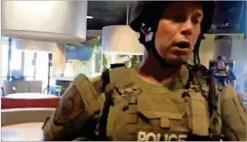  ?? AP PHOTO/THE WASHINGTON POST, WESLEY LOWERY ?? This image shows a police officer confrontin­g Wesley Lowery in a fast-food restaurant in Ferguson, Mo., on Aug. 13, 2014. Lowery and another reporter said they were handcuffed and put into a police van after officers came in to clear the restaurant...