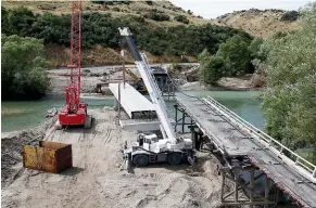  ?? STUFF ?? Work is progressin­g on the new Pyramid Bridge, left, which will replace the old bridge which was damaged by floodwater­s.