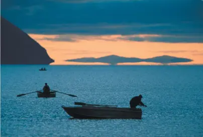  ??  ?? Fishermen on the Okhotsk Sea, at the mouth of the Amur River, which separates Russia and China