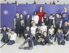  ??  ?? GoodLife4K­ids school program coach Anne-Marie Calhoun catches her breath after a fitness class with physical education team Patrick De Vuono and elementary
students from St. John Vianney School in Rexdale, Ont.