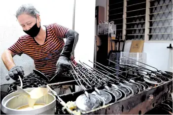  ??  ?? Lau and her husband have been making the traditiona­l ‘kuih kapit’ for 20 years.