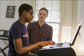  ?? REANN HUBER PHOTOS / REANN.HUBER@AJC.COM ?? James Shealy, right, a music instructor, gives MaKhi Haynes, 13, left, a student in Atlanta, a piano lesson during an afternoon session of the Kevin Baker Music Program in Atlanta on April 5. The program is part of the Friends of English Avenue...