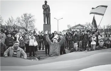  ?? Sergey Ponomarev / New York Times ?? A pro-Russian crowd waves Russian flags during a rally Saturday in front of a government building that was guarded by armed men in Simferopol in the Crimea region of Ukraine.