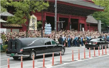  ?? HIRO KOMAE/AP ?? Final goodbye: A hearse carrying the body of former Japanese Prime Minister Shinzo Abe leaves Zojoji temple in downtown Tokyo after his funeral service Tuesday. More than 1,000 mourners attended the funeral. Abe, 67, was assassinat­ed Friday while giving a campaign speech in the western city of Nara. A suspect arrested at the scene remains in police custody.