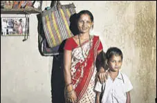  ?? KUNAL PATIL/HT ARCHIVE ?? Ranjana Sonawane stands near a photo of her getting an Aadhaar number, in Maharashtr­a’s Tembhli village.